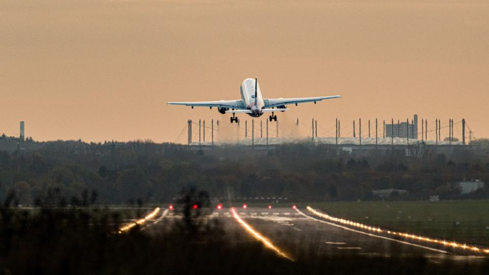 Ein Airbus startet vom Hamburg Airport. Im Hintergrund ist das Volksparkstadion zu sehen.