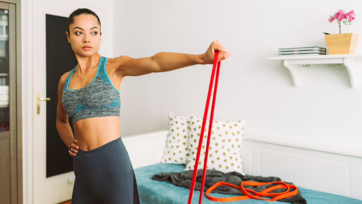  Woman doing arm exercises with resistance band. 