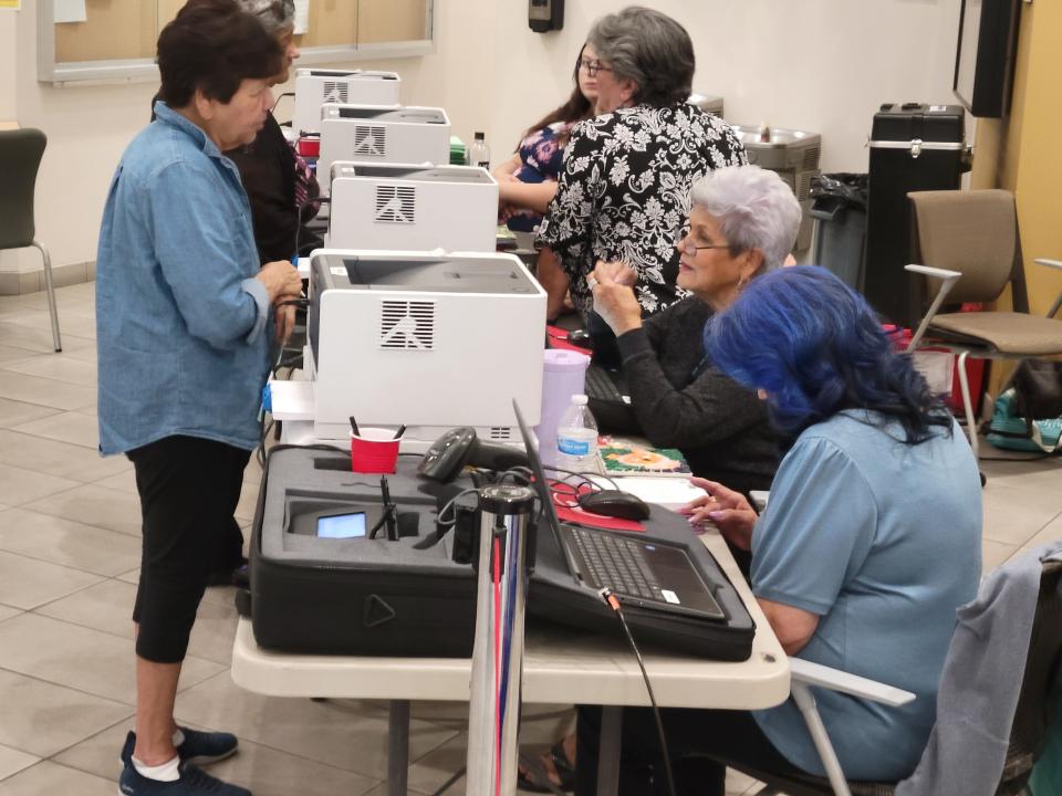 Election workers provide instruction to voters at City Hall on Tuesday, June 4, 2024.