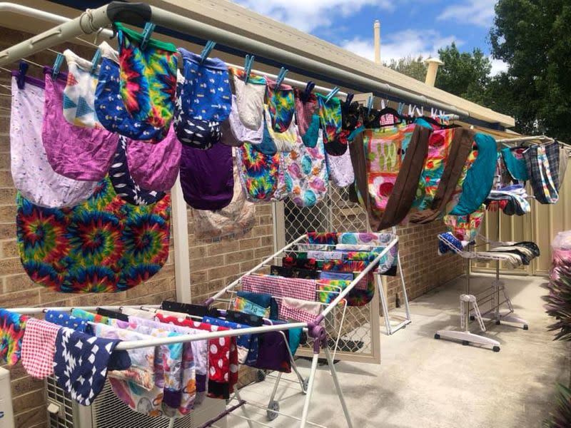 Various completed animal pouches for animals affected by Australia bushfires hang on clothing racks in this January 4, 2020 image obtained via social media, in Regents Park, Queensland