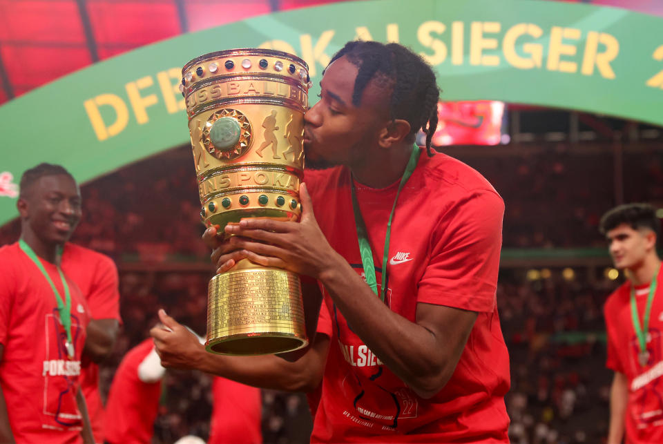 BERLIN, GERMANY - MAY 21: Christopher Nkunku of RB Leipzig kisses the DFB Cup trophy following victory in the final match of the DFB Cup 2022 between SC Freiburg and RB Leipzig at Olympiastadion on May 21, 2022 in Berlin, Germany. (Photo by Alex Grimm/Getty Images)