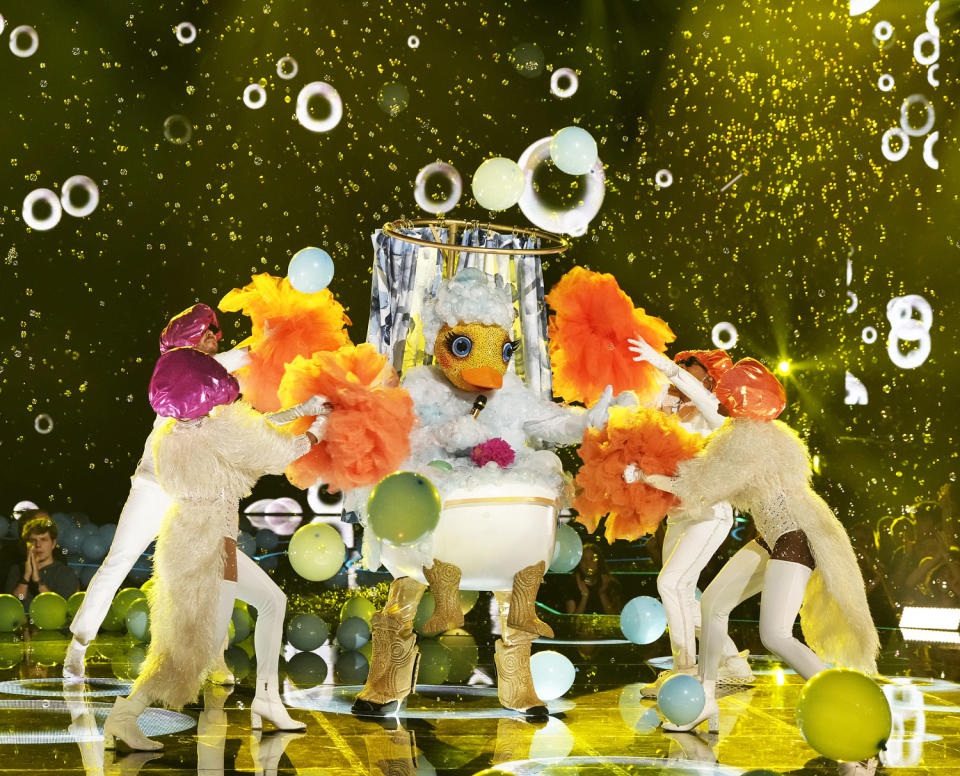 A person in a rubber duck costume in a bathtub dances onstage with four dancers in shower caps (Courtesy of Fox)