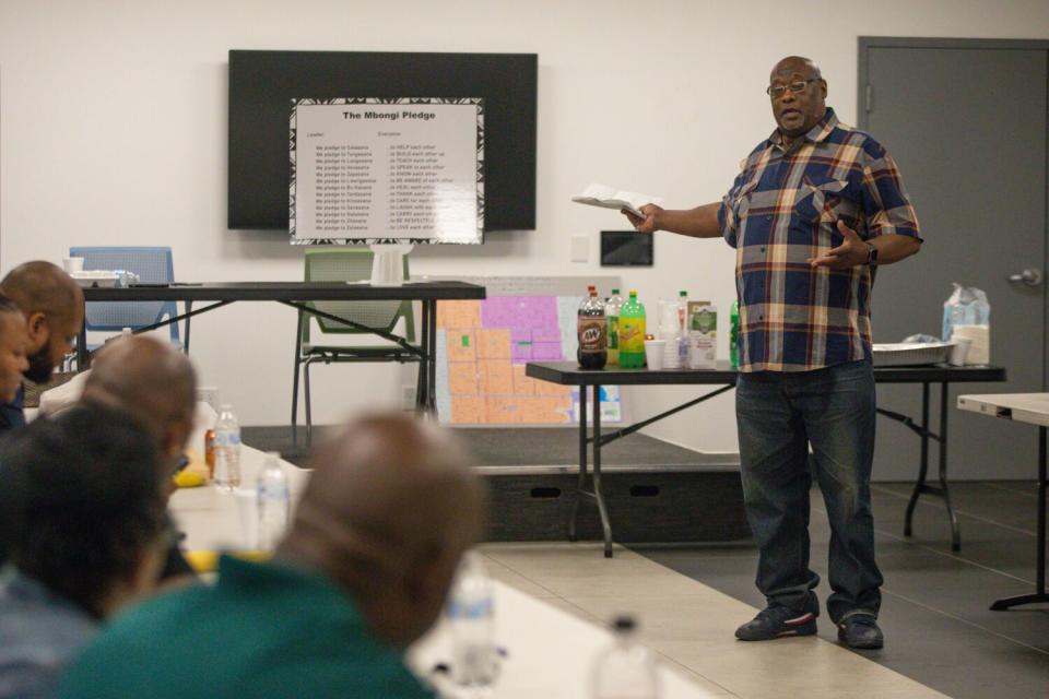 A man standing and talking to a group of people