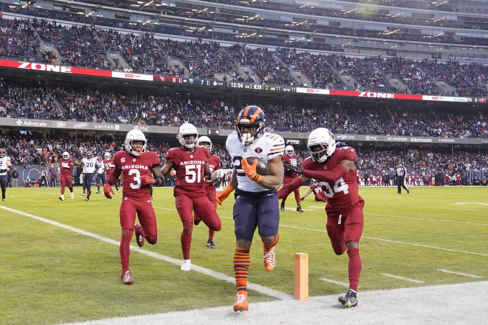 Chicago Bears running back Khalil Herbert scores as Arizona Cardinals safety Jalen Thompson defends during the first half of an NFL football game, Sunday, Dec. 24, 2023, in Chicago. (AP Photo/David Banks)