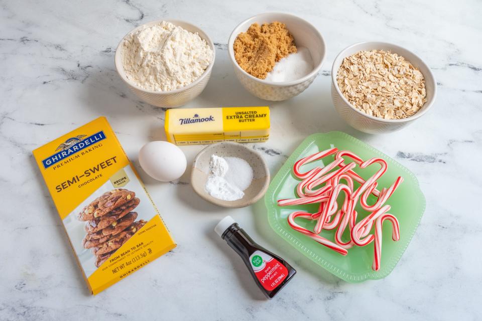 Semi-sweet chocolate, butter, peppermit extract, mini candy canes, flour, sugars, and other ingredients on a white countertop