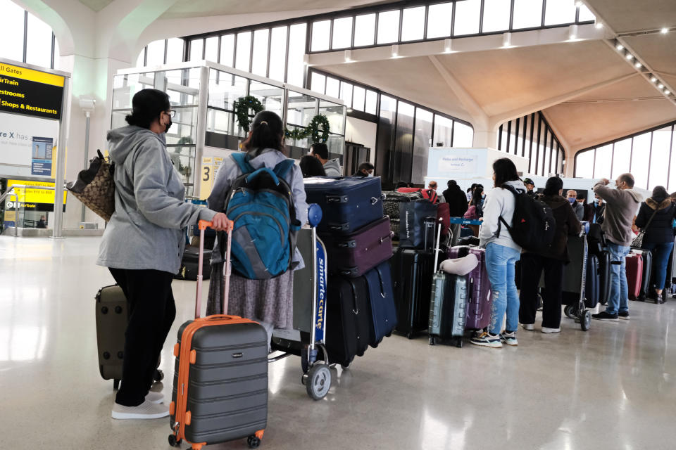 Travelers arrive for flights at Newark Liberty International Airport on November 30, 2021 in Newark, New Jersey. (Photo by Spencer Platt/Getty Images)