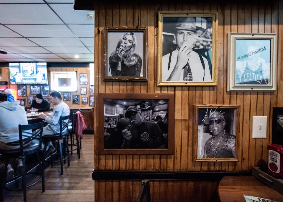 Framed photos of celebrities smoking line the walls inside Gleason's Bar, in Levittown, as an homage to its former smoking bar days.