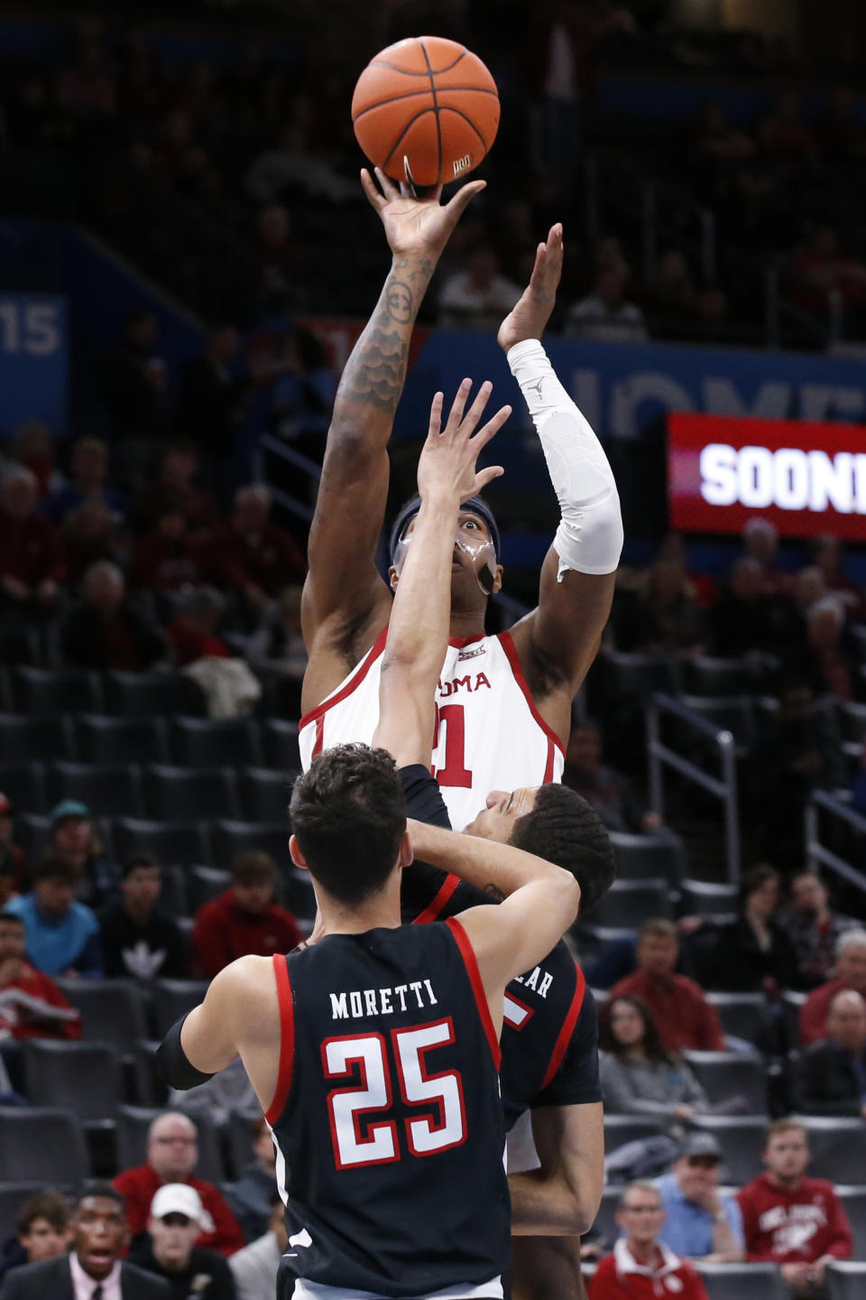 Oklahoma forward Kristian Doolittle, rear, shoots over Texas Tech guard Davide Moretti (25) and guard Kevin McCullar, center, in the first half of an NCAA college basketball game Tuesday, Feb. 25, 2020, in Oklahoma City. (AP Photo/Sue Ogrocki)