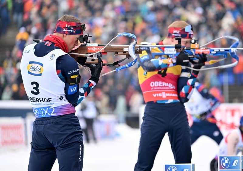 Norway's Endre Stroemsheim (L) and Norway's Johannes Thingnes Boe in action at the shooting range during the men's pursuit 12.5 km of the Biathlon World Cup in the Lotto Thüringen Arena at Rennsteig. Martin Schutt/dpa