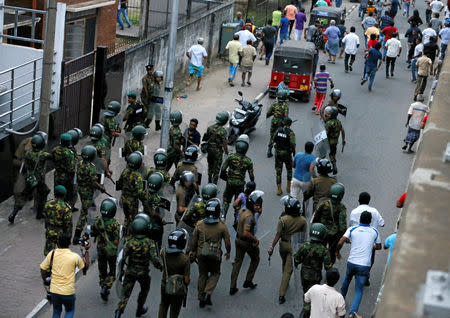 Members of Sri Lanka's Special Task Force and the police chase away supporters of Sri Lanka's newly appointed Prime Minister Mahinda Rajapaksa after an official security guard of sacked minister Arjuna Ranatunga shot and wounded three people in front of the Ceylon Petroleum Corporation, in Colombo, Sri Lanka October 28, 2018. REUTERS/Dinuka Liyanawatte