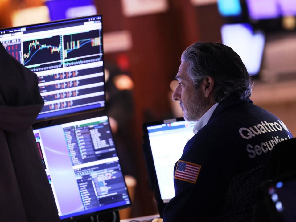  A trader works on the floor of the New York Stock Exchange. Stocks are gaining Friday.