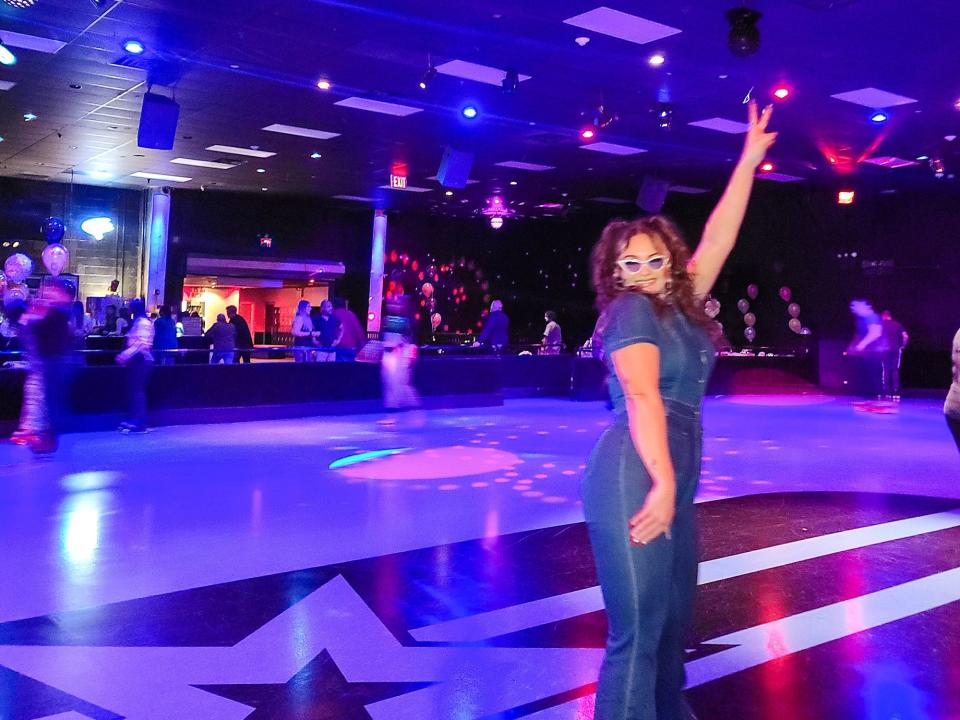 A woman in a jumpsuit standing under a disco ball