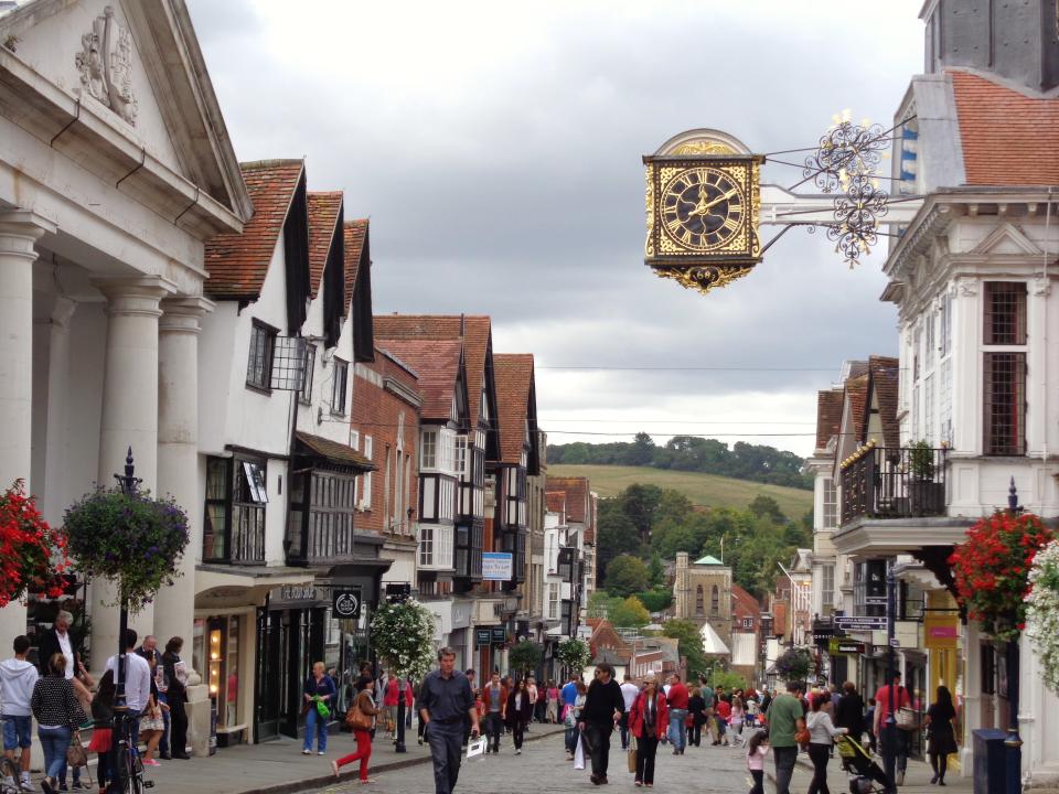 Guildford is a picturesque market and university town in Surrey. this photo shows the town hall clock and the steep slope of the high street going towards the River Wey.