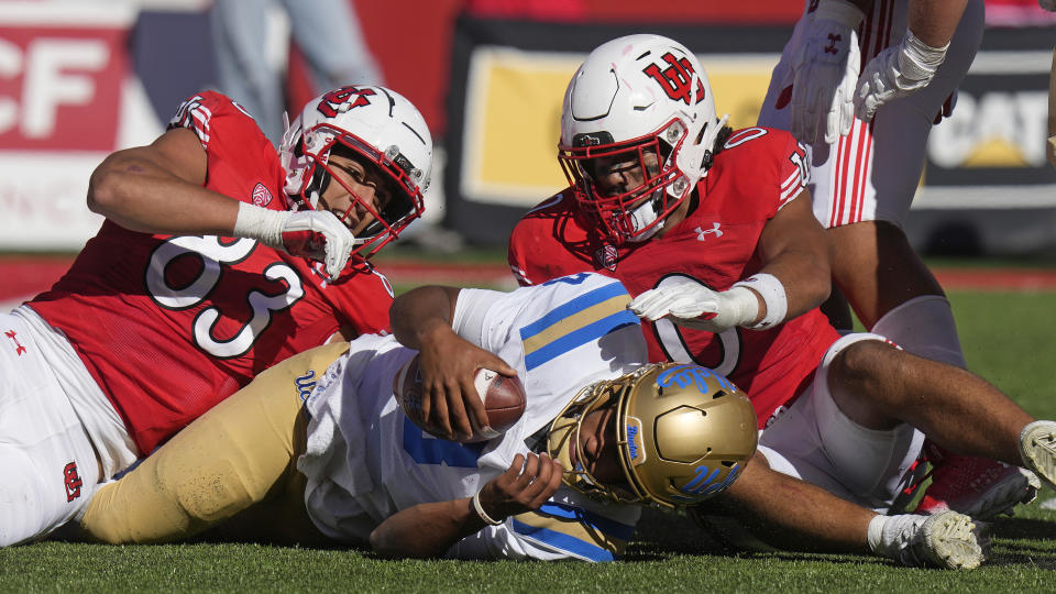 Utah's Jonah Elliss (83) and Logan Fano (0) sack UCLA quarterback Dante Moore, center, during the second half of an NCAA college football game, Saturday, Sept. 23, 2023, in Salt Lake City. (AP Photo/Rick Bowmer)