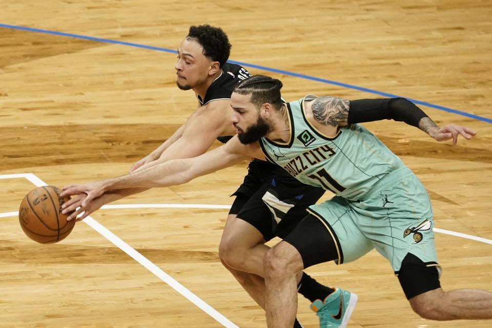 Milwaukee Bucks' Bryn Forbes and Charlotte Hornets' Cody Martin go after a loose ball during the first half of an NBA basketball game Friday, April 9, 2021, in Milwaukee. (AP Photo/Morry Gash)