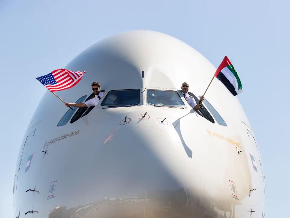 Etihad pilots hand out the windows of the A380 with the US and UAE flags.