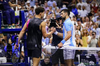 Novak Djokovic, right, of Serbia, shakes hands with Ben Shelton, of the United States, after winning their match during the men's singles semifinals of the U.S. Open tennis championships, Friday, Sept. 8, 2023, in New York. (AP Photo/Frank Franklin II)