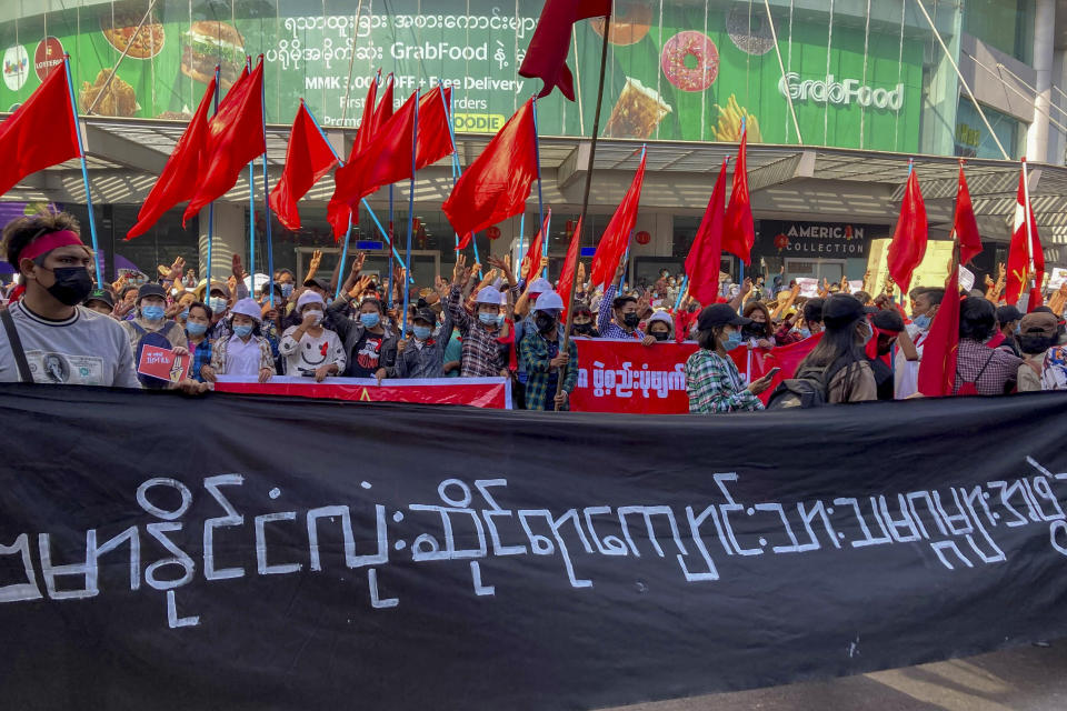 Campaigners with National League for Democracy party flags gather at an intersection in Yangon, Myanmar, Tuesday, Feb. 9, 2021. Protesters continued to gather Tuesday morning in Yangon breaching Myanmar's new military rulers ban of public gathering of five or more issued on Monday intended to crack down on peaceful public protests opposing their takeover. The banner reads: "All Burma Students Union." (AP Photo)