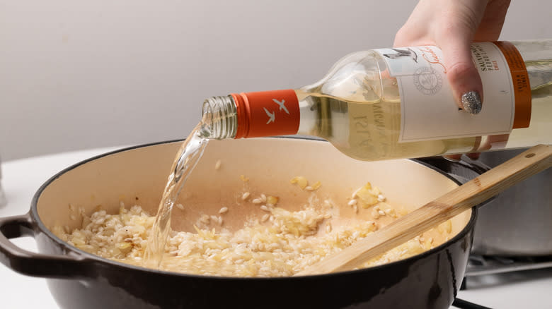 pouring wine into risotto base
