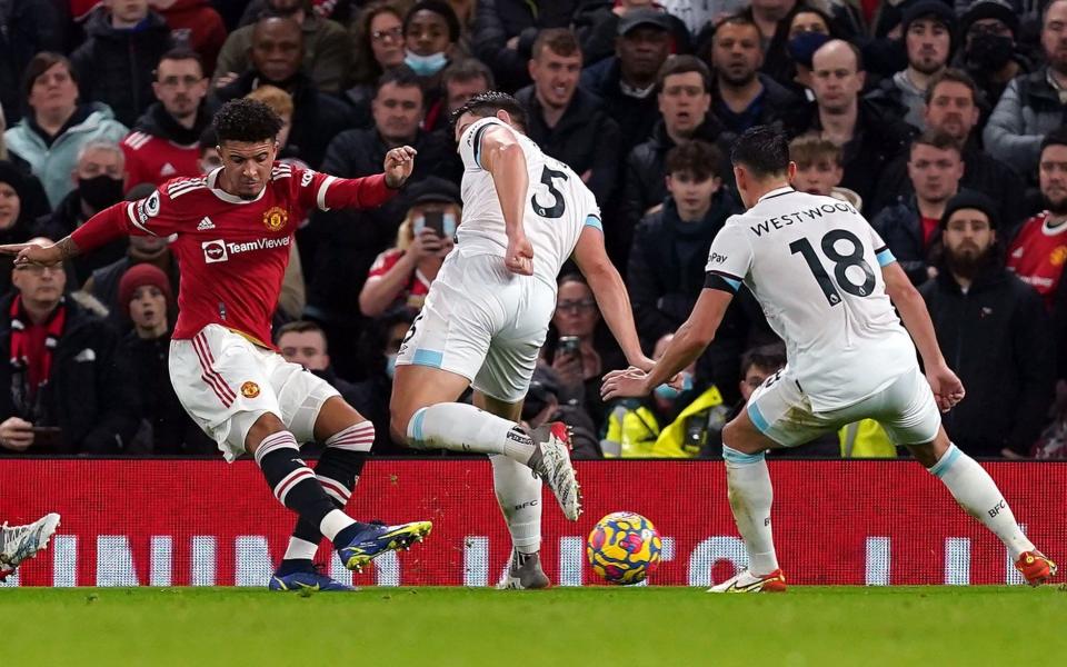 Manchester United's Jadon Sancho (left) shots towards goal as their side's second goal of the game is scored by Burnley's Ben Mee - Martin Rickett/PA Wire