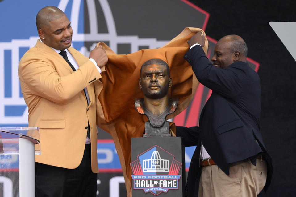 Former NFL player Richard Seymour, left, and his high school principal Titus Durea unveil his bust before speaking during his induction into the Pro Football Hall of Fame, Saturday, Aug. 6, 2022, in Canton, Ohio. (AP Photo/David Richard)