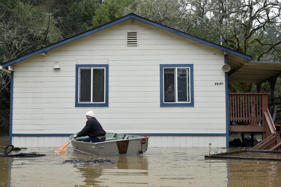 A man paddles a boat near a home surrounded by flood waters from the Russian River in Forestville, Calif., on Feb. 27, 2019. (Photo: Michael Short/AP)