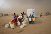 <p>ABS IDP Settlement, Yemen, May 6, 2017: Internally displaced persons (IDPs) collect water in a brooding sandstorm. Water is heavily rationed and is only available during one-hour windows, which normally take place only three times a day. (Photograph by Giles Clarke for UN OCHA/Getty Images) </p>