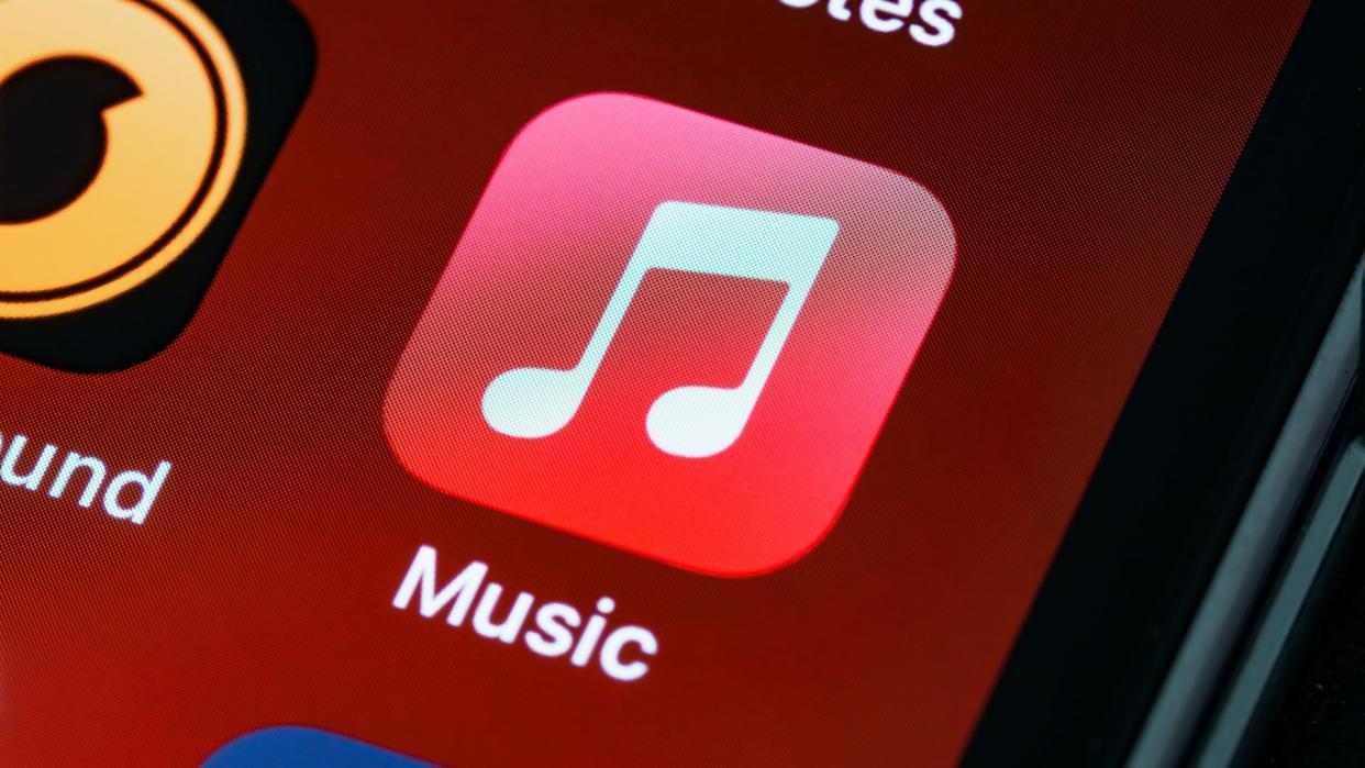  The Apple Music app icon against a red background on an iPhone. 