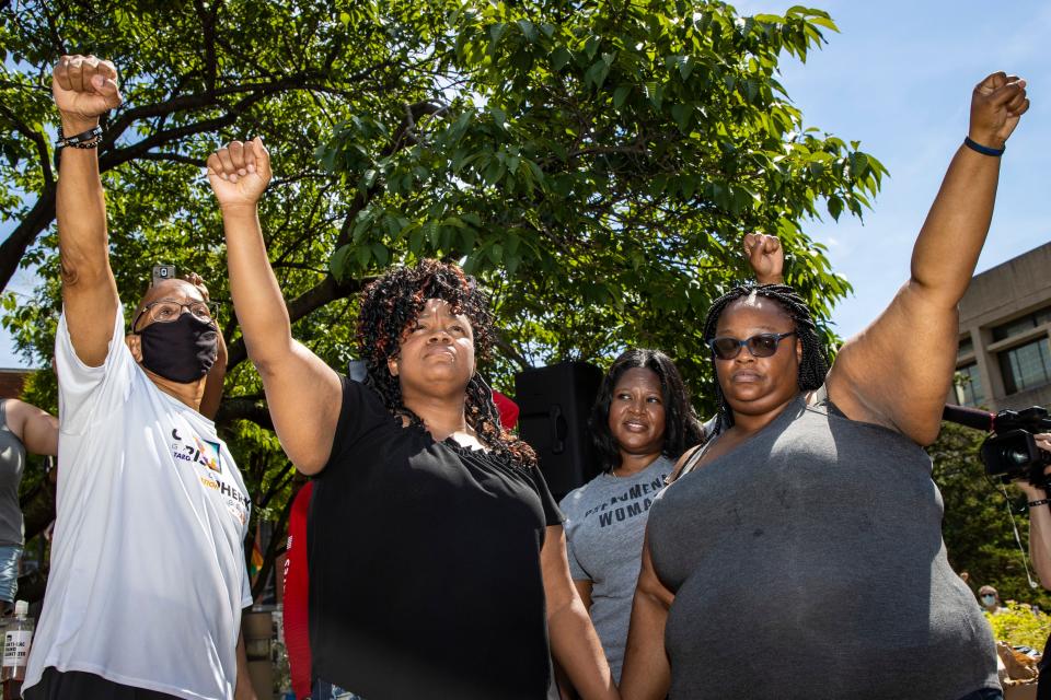 Breonna Taylor's mother, Tamika Palmer, second from left, raises her fist in solidarity with supporters in Jefferson Square Park on what would have been Breonna Taylor's 27th birthday. June 5, 2020