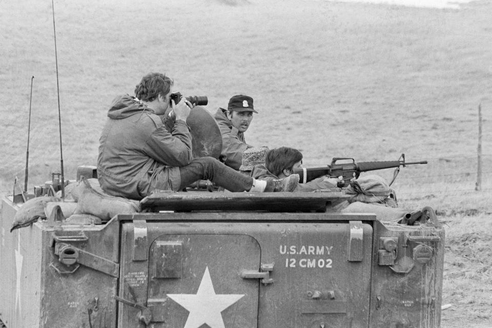 FILE - Government agents maintain watch on American Indian Movement members who have been in control of the village for over three weeks at Wounded Knee, S.D., on March 24, 1973. (AP Photo/Fred Jewell, File)