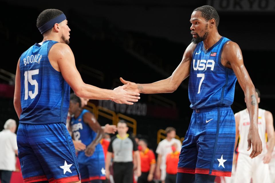 Devin Booker (15) and Kevin Durant congratulate each other after Team USA defeated Spain in an Olympic men's basketball quarterfinal game.