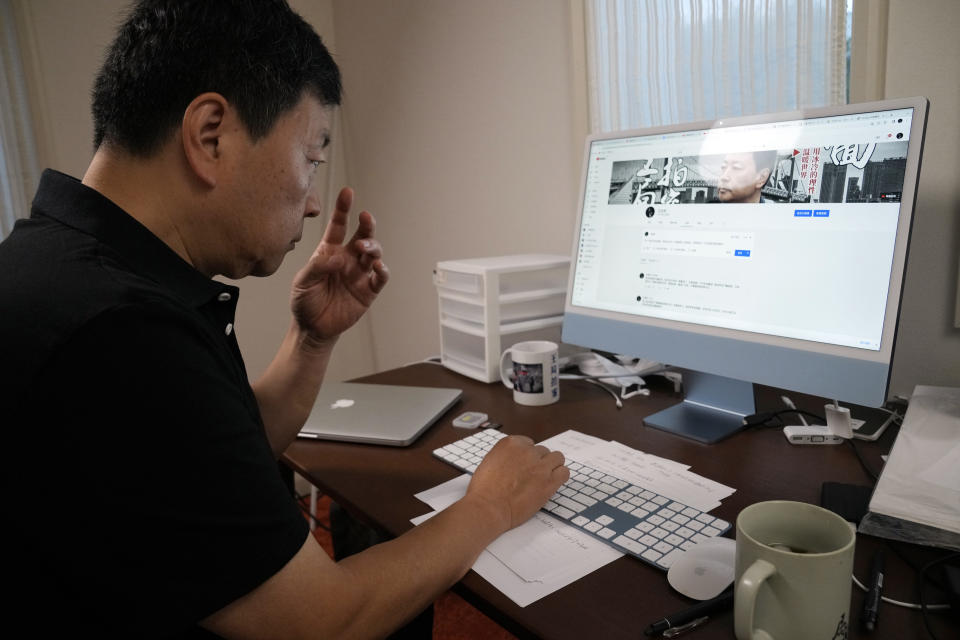 Wang Zhi'an checks his website during an interview with the Associated Press in Tokyo on Oct. 5, 2022. Chinese investigative journalist Wang once exposed corruption, land seizures, and medical malpractice for state broadcaster CCTV. Today, he's in exile in Japan, and starting again as an independent journalist on YouTube. (AP Photo/Eugene Hoshiko)