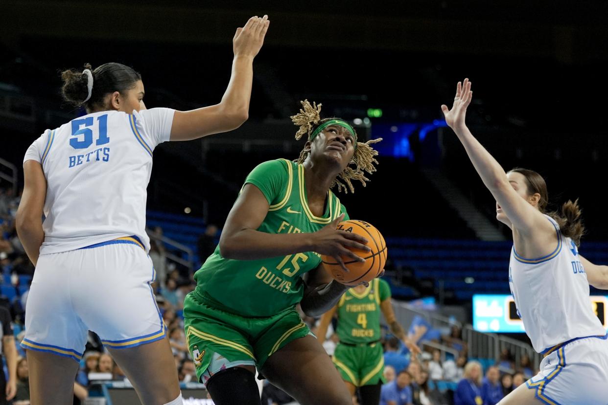 Oregon center Phillipina Kyei (15) is defended by UCLA center Lauren Betts (51) and forward Angela Dugalic, right, during the first half of an NCAA college basketball game in Los Angeles, Friday, Jan. 5, 2024.