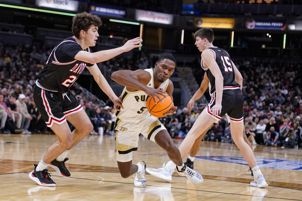 Purdue guard Brandon Newman (5) drives past Davidson guard Achile Spadone (20) in the first half of an NCAA college basketball game in Indianapolis, Saturday, Dec. 17, 2022. (AP Photo/Michael Conroy)