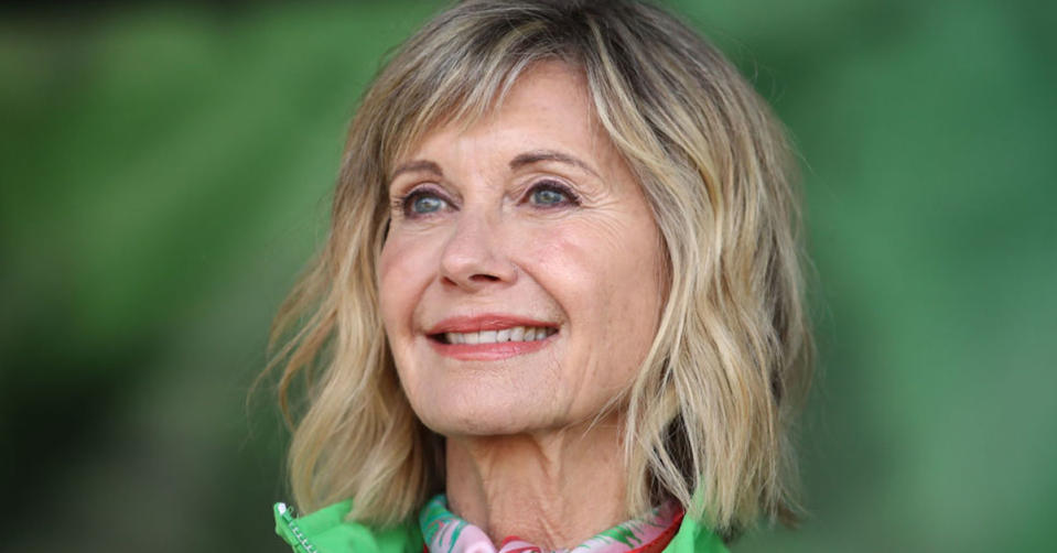 Olivia Newton-John against a green background