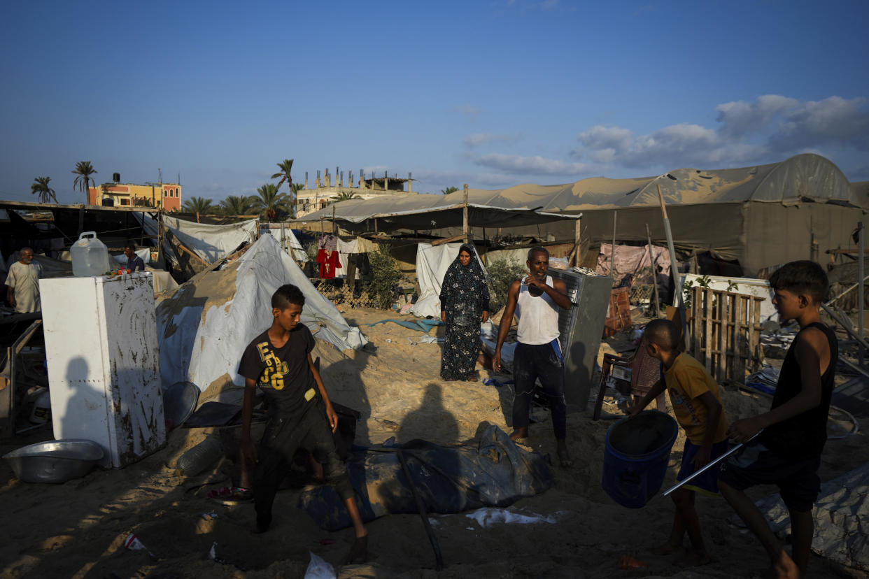 Palestinians look at the destruction after an Israeli airstrike on a crowded tent camp housing Palestinians displaced by the war in Muwasi, Gaza Strip, Tuesday, Sept. 10, 2024. An Israeli strike killed at least 40 people and wounded 60 others early Tuesday, Palestinian officials said. Israel said it targeted "significant" Hamas militants, allegations denied by the militant group. (AP Photo/Abdel Kareem Hana)