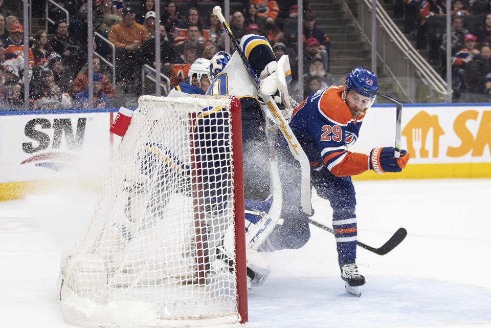 Edmonton Oilers' Leon Draisaitl crashes into St. Louis Blues goalie Jordan Binnington (50) during overtime in an NHL hockey game Wednesday, Feb. 28, 2024, in Edmonton, Alberta. (Jason Branson/The Canadian Press via AP)