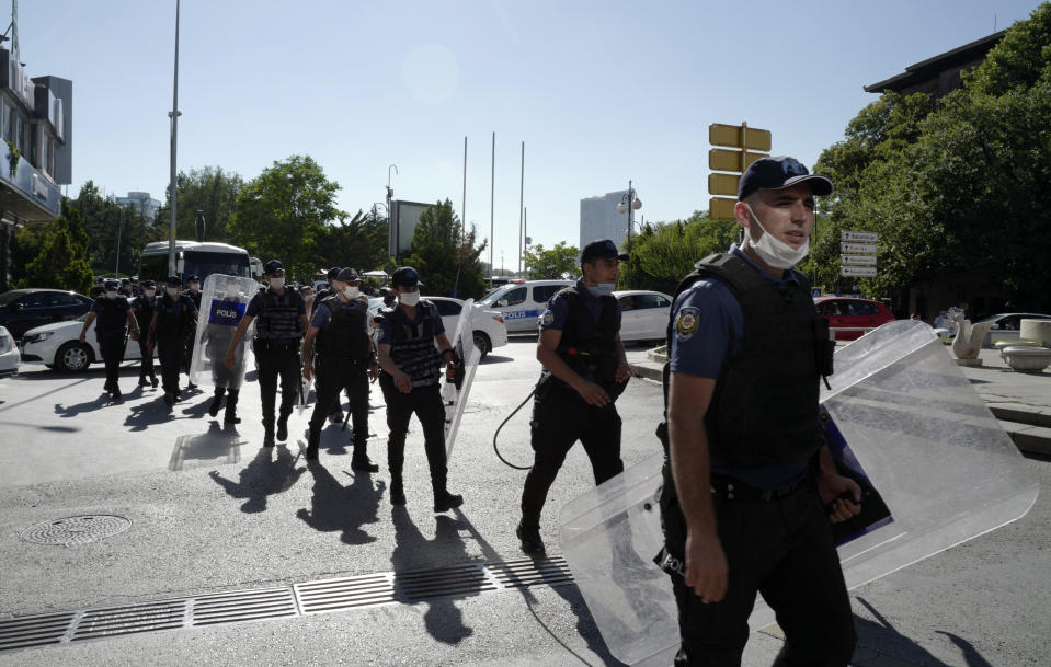 Riot police officers follow lawyers who try to walk to the parliament, in Ankara, Turkey, Friday, July 10, 2020. Turkey's Bar Associations continue to protest against the government's plans to amend laws regulating on lawyers and their associations. (AP Photo/Burhan Ozbilici)