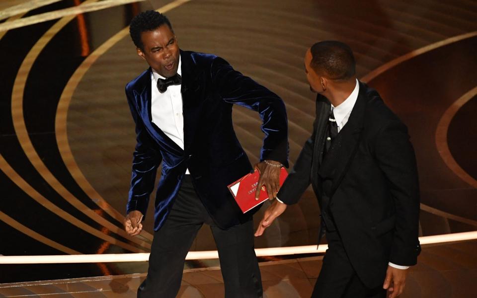 Ouch: Chris Rock reacts to Will Smith's assault at the 2022 Oscars - Robyn Beck / AFP) (Photo by ROBYN BECK/AFP via Getty Images