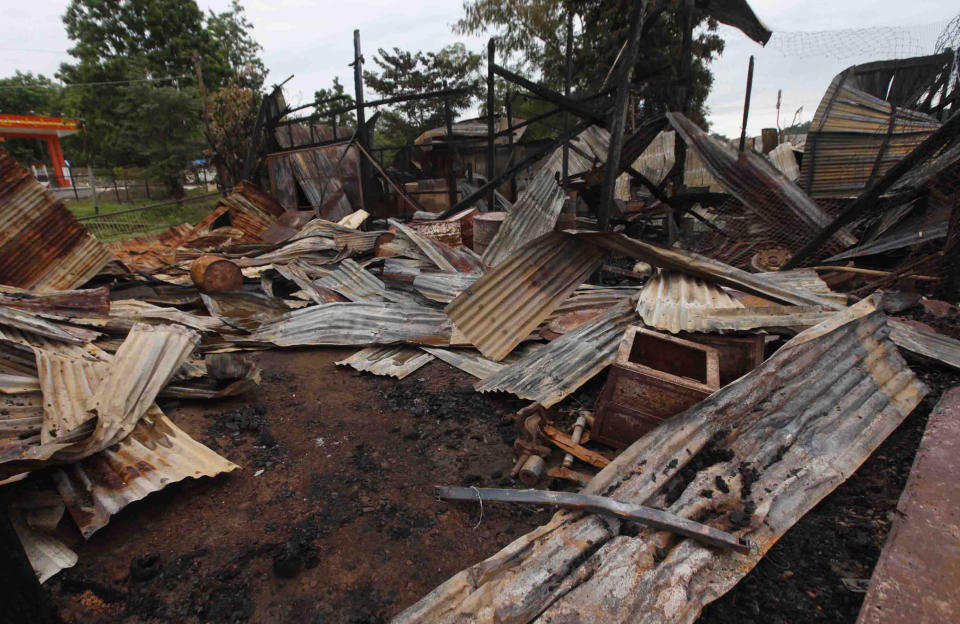 Distorted corrugate panels are scattered among debris of a burnt building Wednesday, Oct. 2, 2013, in Thandwe, Rakhine State, western Myanmar. Terrified Muslim families hid in forests in western Myanmar on Wednesday, one day after rampaging Buddhist mobs killed a 94-year-old woman and burned dozens of homes despite the first trip to the volatile region by President Thein Sein since unrest erupted last year. The violence near Thandwe, a coastal town the president was due to visit later Wednesday on the second day of his tour of Rakhine state, raised new questions about government's failure to curb anti-Muslim attacks and or protect the embattled minority. (AP Photo/Khin Maung Win)