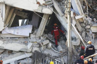 Rescuers work on searching for people buried under the rubble on a collapsed building, after an earthquake struck Elazig, eastern Turkey, Saturday, Jan. 25, 2020. Rescue workers were continuing to search for people buried under the rubble of apartment blocks in Elazig and neighbouring Malatya. Mosques, schools, sports halls and student dormitories were opened for hundreds who left their homes after the quake (IHH/ Humanitarian Relief Foundation via AP)