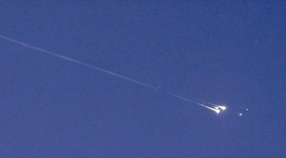 a piece of space junk called wt1190f erupts in a fireball with a trail of dust behind it in the sky