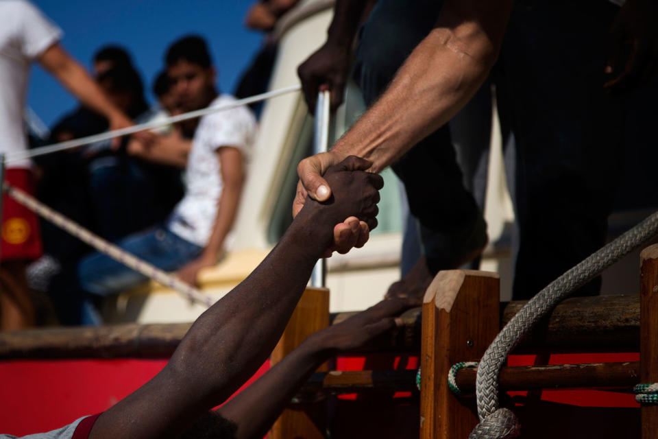 <p>A migrant from Nigeria is helped by a members of Proactiva Open Arms NGO, to get into the Astral vessel, during a rescue operation at the Mediterranean sea, about 17 miles north of Sabratah, Libya, Saturday, Aug. 20, 2016. Migrants seemingly prefer to face the dangers of the journey towards Europe, rather than stay at home.(AP Photo/Emilio Morenatti) </p>