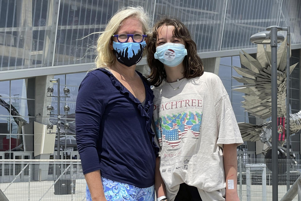 English Norman and her 12-year-old daughter, Jane Ellen Norman, pose for a photo outside Mercedes-Benz Stadium in Atlanta on Tuesday, May 11, 2021. Jane Ellen and her 14-year-old brother Owen were vaccinated Tuesday morning, just after U.S. regulators expanded use of Pfizer's COVID-19 shot to those as young as 12. (AP Photo/Angie Wang)