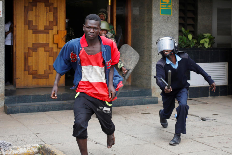 Kenyan policemen rush tobeat a protester during clashes in Nairobi, Kenya, May 16, 2016. (Reuters/Goran Tomasevic)