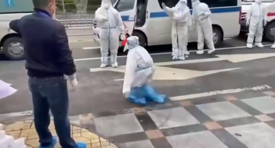 Video circulating online shows a child in adults' PPE being directed to an ambulance for quarantine. Source: Shanghai Observed