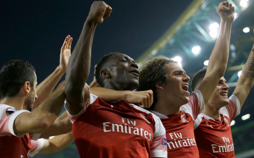 Danny Welbeck celebrates scoring against Sporting Lisbon with his Arsenal team-mates - AP