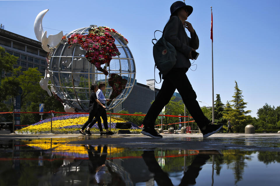 People walk by a globe structure showing the United States of America on display outside a bank in Beijing, Monday, May 6, 2019. U.S. President Donald Trump raised pressure on China on Sunday, threatening to hike tariffs on $200 billion worth of Chinese goods in a tweet that sent financial markets swooning. Trump's comments, delivered on Twitter, came as a Chinese delegation was scheduled to resume talks in Washington on Wednesday aimed at resolving a trade war that has shaken investors and cast gloom over the world economy. (AP Photo/Andy Wong)