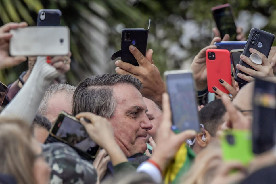 Brazil's former President Jair Bolsonaro is greeted by supporters after landing at the airport in Porto Alegre, Brazil, Thursday, June 22, 2023. Brazil’s top electoral court on Thursday began hearing a case which claims the he abused his power by using government communication channels to promote his campaign and cast unfounded doubts on the country’s electronic voting system, which could render him ineligible for public office for eight years. (AP Photo/Wesley Santos)