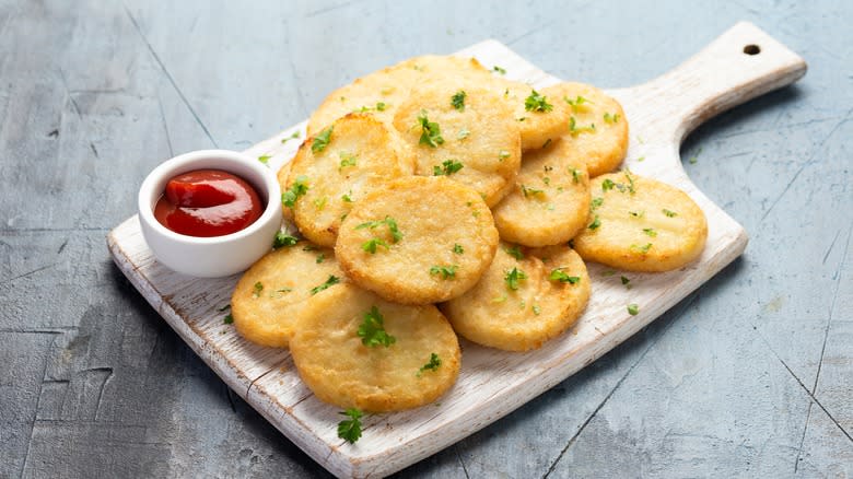 cauliflower pancakes on a rustic cuting board with ketchup